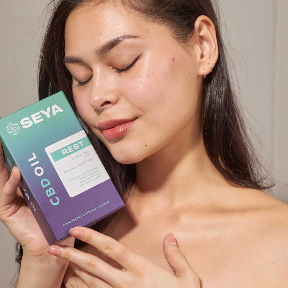 a woman use seya cbd oil on her skin